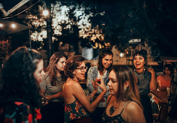 a group of women laughing at a party at night