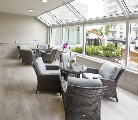 A seating area with chairs and tables in front of a large window