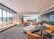 Thumbnail 14 of 24 - A modern office space with a wooden ceiling and a large screen on the wall.