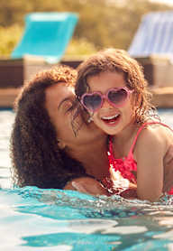 A woman and a girl are swimming in a pool.