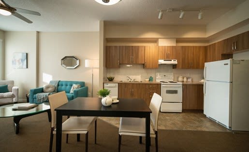 a kitchen and living room with a table and chairs