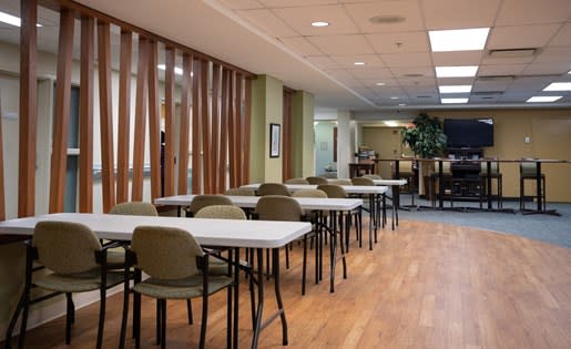 a room filled with lots of white tables and chairs