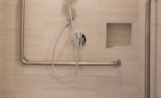 a shower with a hose and a handle