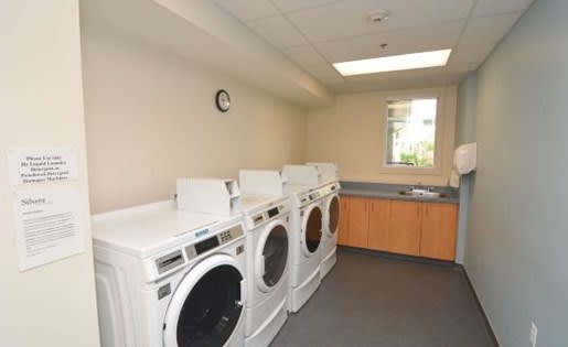 a room with four washers and a sink