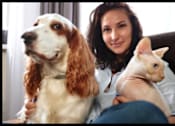 Thumbnail 2 of 5 - A woman is holding a dog and a rabbit.