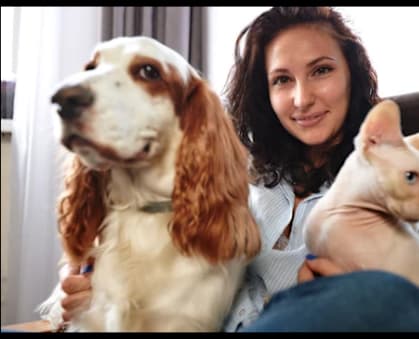 A woman is holding a dog and a rabbit.