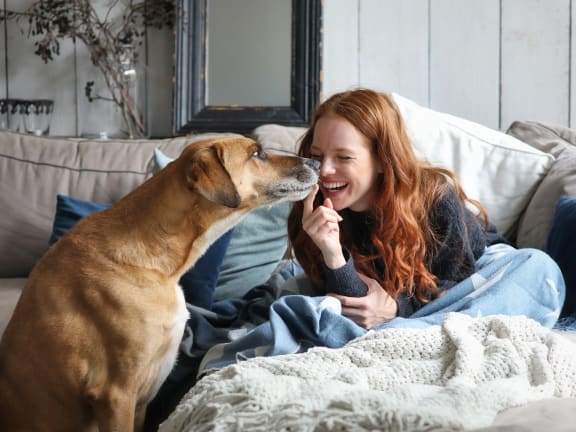 a girl and her dog sitting on a couch