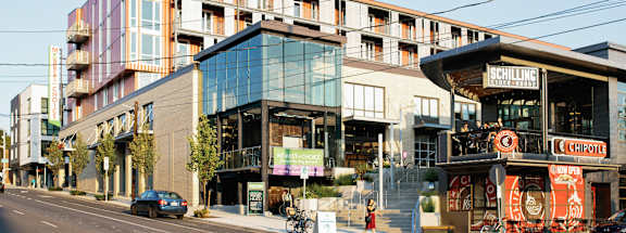 A street view of a building with a Schilling sign on the top floor.