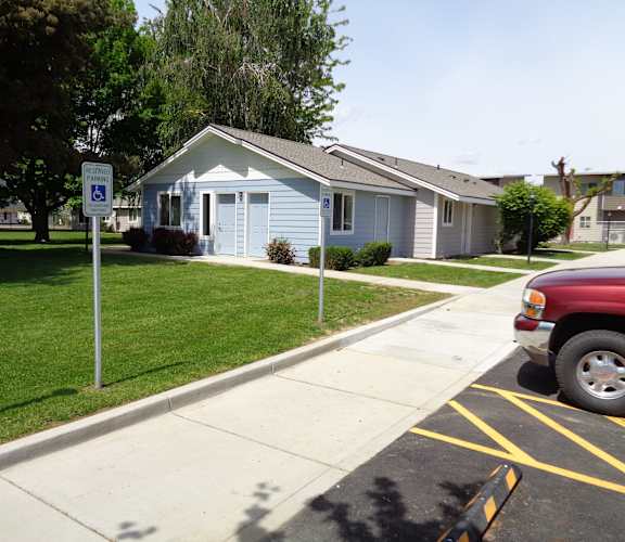 A blue house with a white door and a sign in front of it.