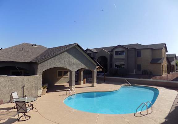 A swimming pool in a backyard with a house in the background.
