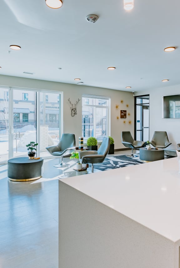 a kitchen with a bar and yellow chairs in a large room