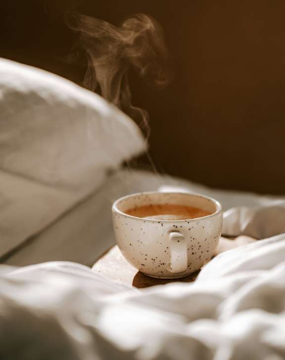 A cup of coffee with steam rising from it.