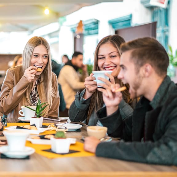 a group of people sitting around a table eating and drinking coffee at Northern Lights a Lifestyle-Driven Community, North Dakota