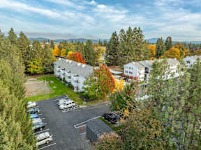 A parking lot with cars and a building in the background. at Ironwood Apartments, Coeur dAlene