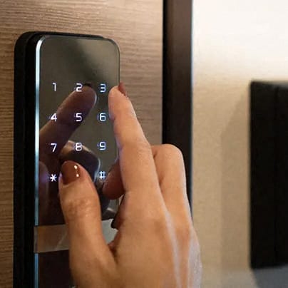 a person pressing a remote control on a door handle