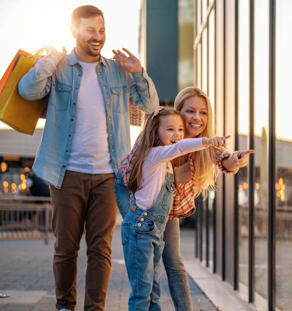 a man and woman walking down the street with a little girl