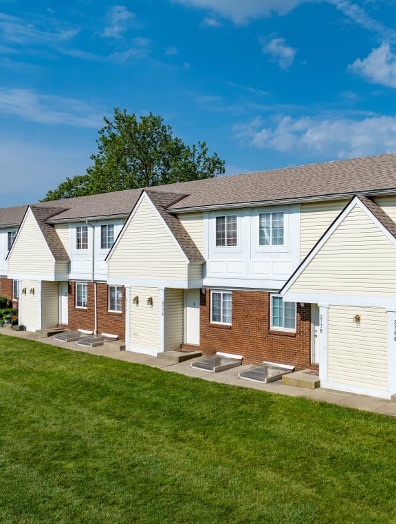 a row of houses with white siding and red brick