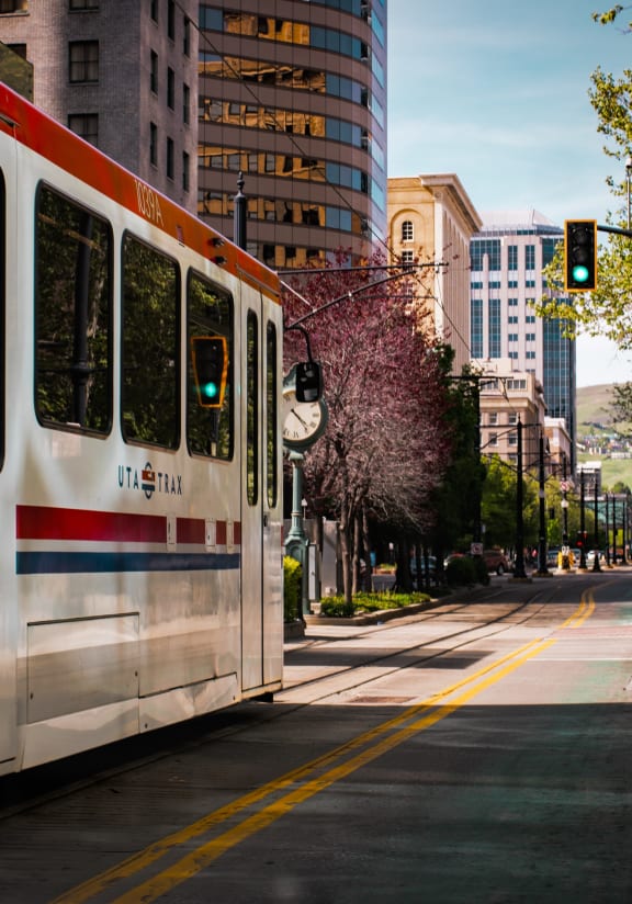 a blue and white train pulls into a station in the middle of a city
