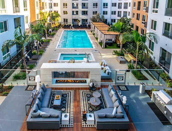 A large outdoor area with a pool and a barbecue grill. at Baker Block, Costa Mesa, California