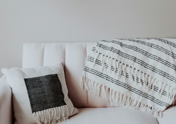 a couch with pillows and a blanket on it at Brookhollow Apartments, West Covina , California