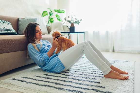 a woman laying on the floor with her dog