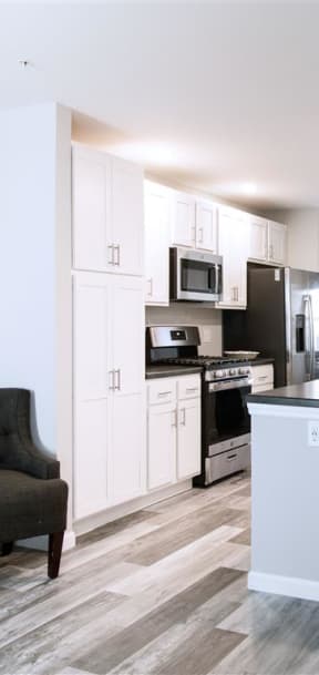 a kitchen with white cabinets and a black stove and refrigerator