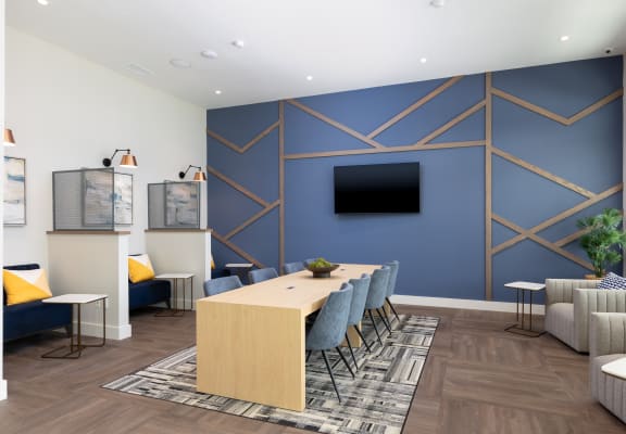 a conference room with a blue accent wall and a wooden table