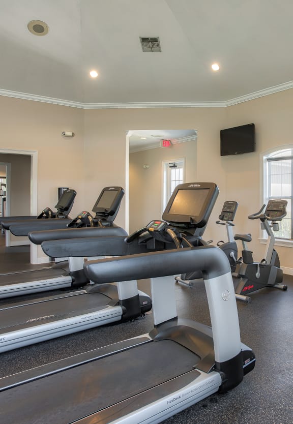 a room with a row of treadmills and exercise machines