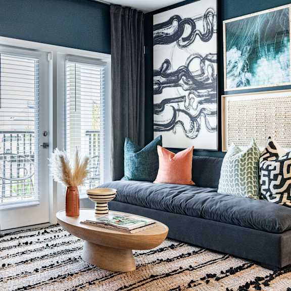 A living room with a dark blue sofa and a wooden coffee table.