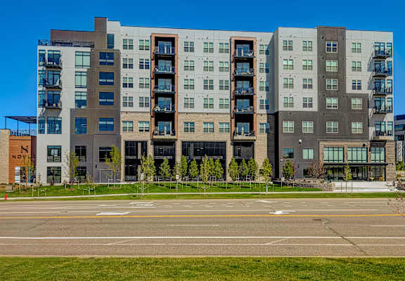 A modern multi-story building with a mix of window sizes and balconies.
