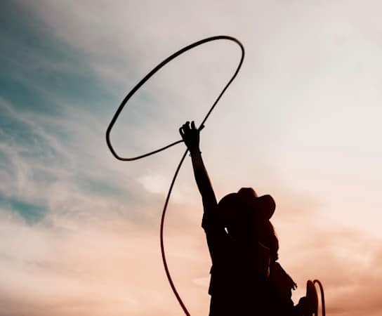 A silhouette of a person holding a hula hoop.