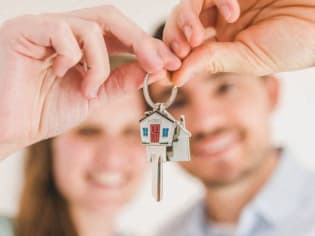 a man and woman holding a house key