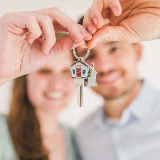 a man and woman holding a house key