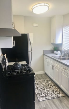 a kitchen with a stove and a sink  at The Marq Apartments LLC, Los Angeles, California