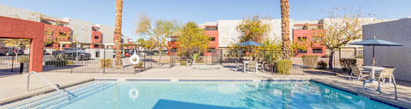 A swimming pool in a sunny outdoor setting.