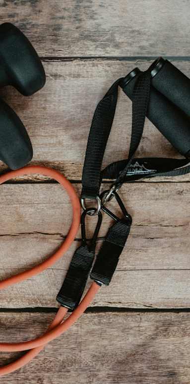 Two black dumbbells and a red jump rope on a wooden surface.at Alante Homes at Spring Run, Caldwell Idaho