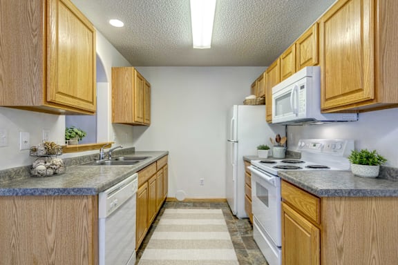 A kitchen with wooden cabinets and white appliances.