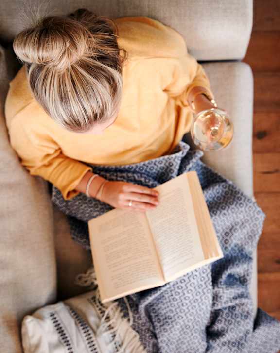 woman reading a book with glass in hand at Oak Park City, Oak Park