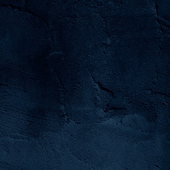 a blue stone wall with a rough texture and a dark shade of blue