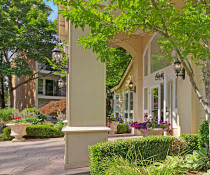 The front porch of Adagio with a tree in front of it. 