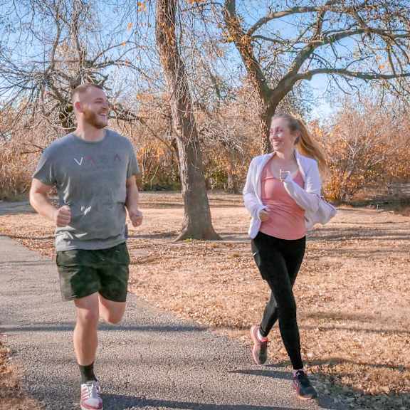 A man and a woman running down a road at Cheyenne Creek.