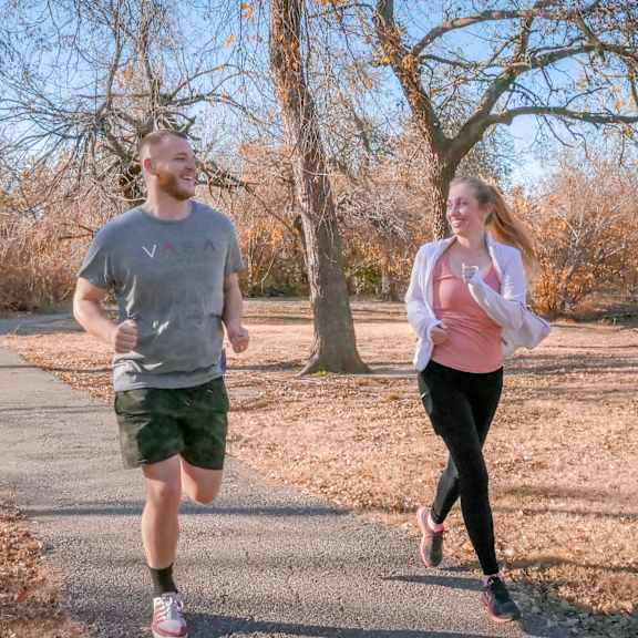 A man and a woman running down a road at Manning Crossing Apartment Homes.