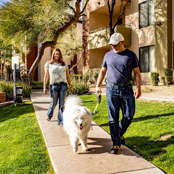 A couple walking their dog at Eagle Ridge Apartment Homes.