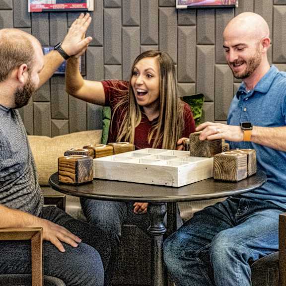 A group of people sitting around a table playing board games at Birchwood Apartment Homes. 