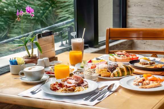 A breakfast table with a variety of foods and drinks.
