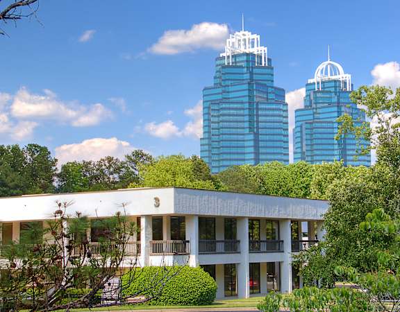 A white building with a green lawn in front of it.