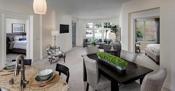 a living room and dining room with a table and chairs