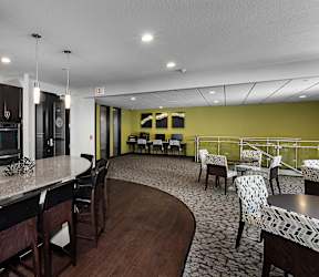 A kitchen with a counter and chairs.