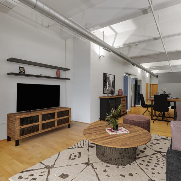 a living room with a couch and a table at The Lofts at Elk Terminal Apartments , Buffalo, NY