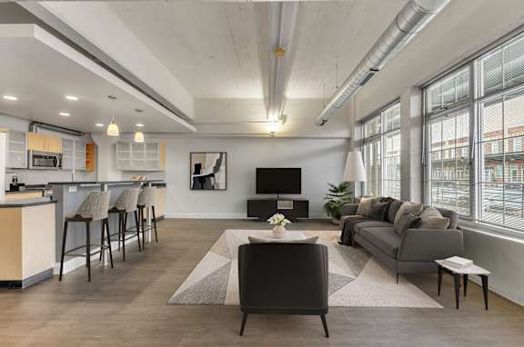 A modern living room with a bar area and a grey sofa.